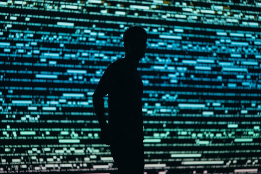 Silhouette of a man standing in front of a screen of colored lights